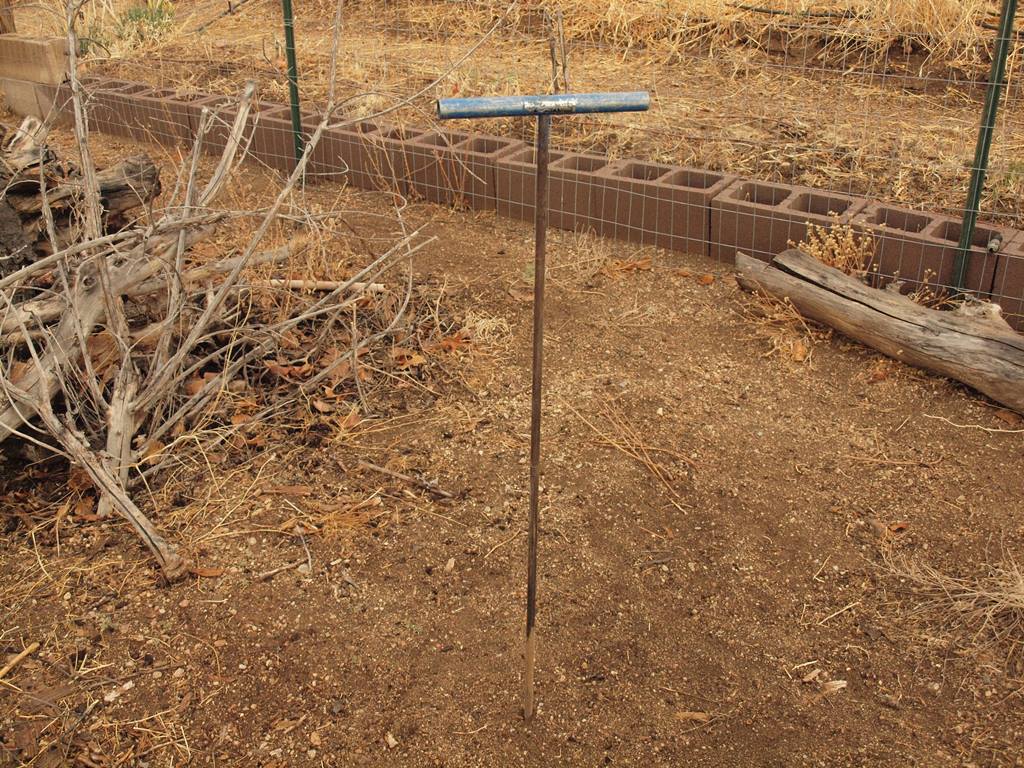 Paul Brown soil moisture probe inserted into soil to determine depth of moist soil